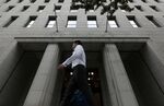 A pedestrian walks past the Nippon Life Insurance Co. headquarters in Osaka, Japan.