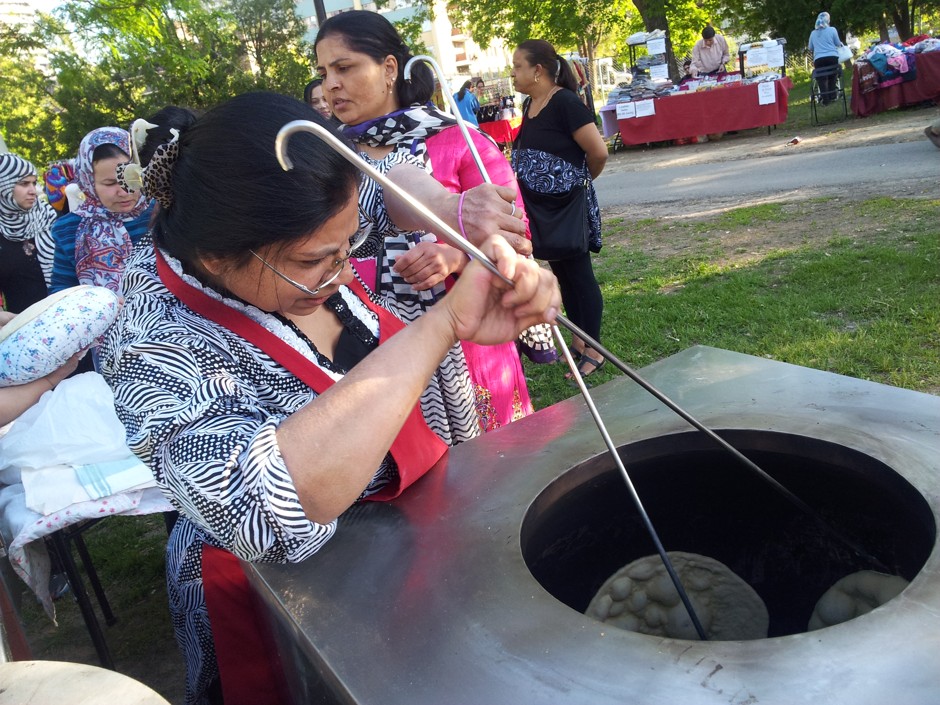 A resident prepares naan in Toronto's new public tandoor oven.  