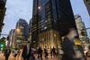 Pedestrians walk past the Mizuho Financial Group Inc. headquarters, center, at dusk in Tokyo, Japan.