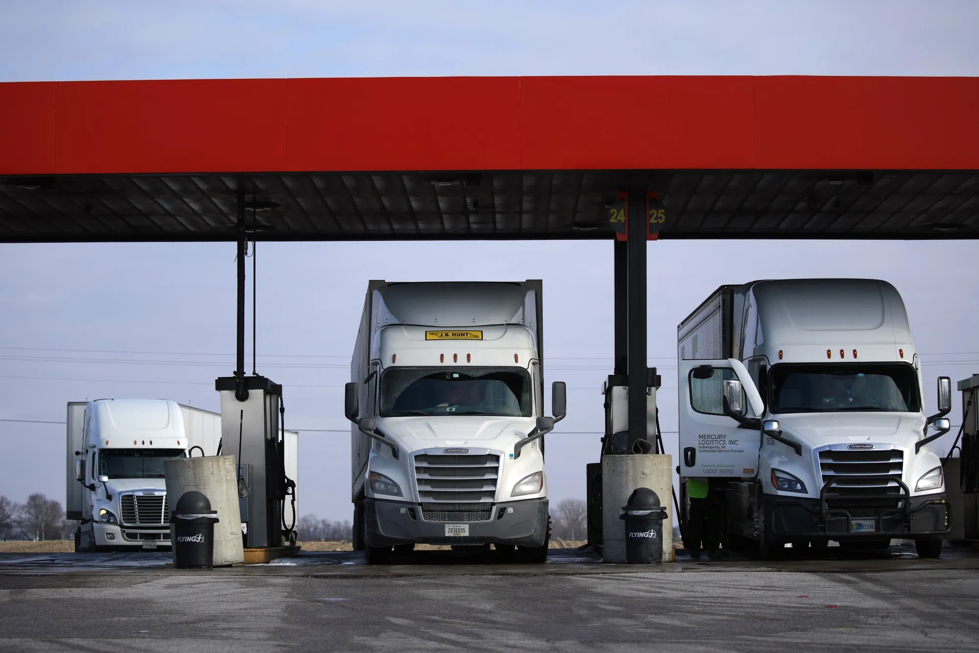 Tractor trailers parked at a truck stop fuel pump in Whiteland, Indiana.