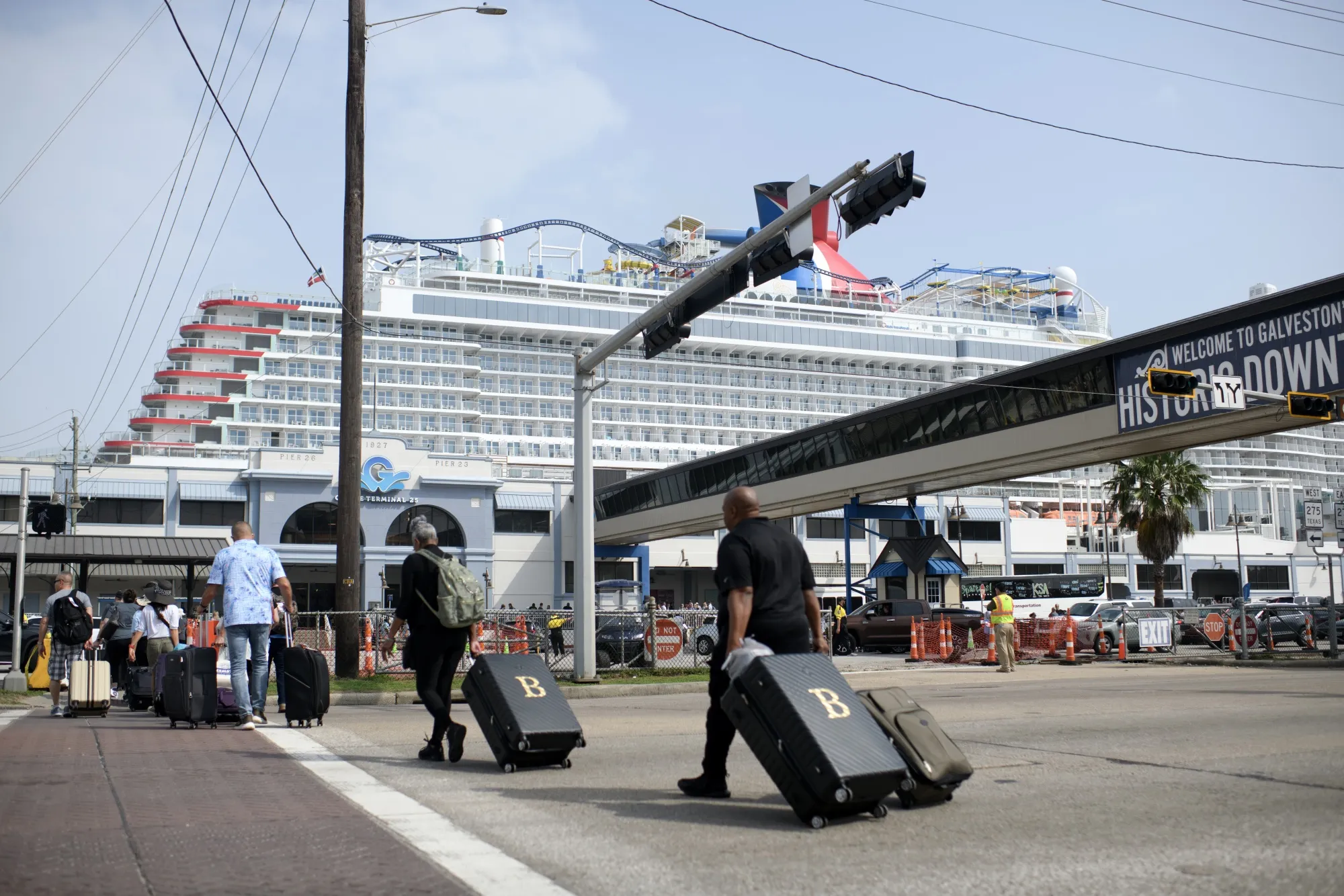 People cross Harborside Drive to get to the cruise terminals in Galveston, TX, U.S., on Saturday, April 5, 2025.