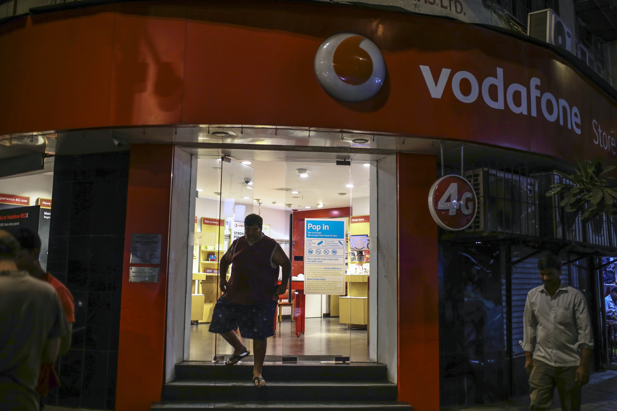 Buyer is leaving Vodafone Idea Ltd. store.  in Mumbai, India.