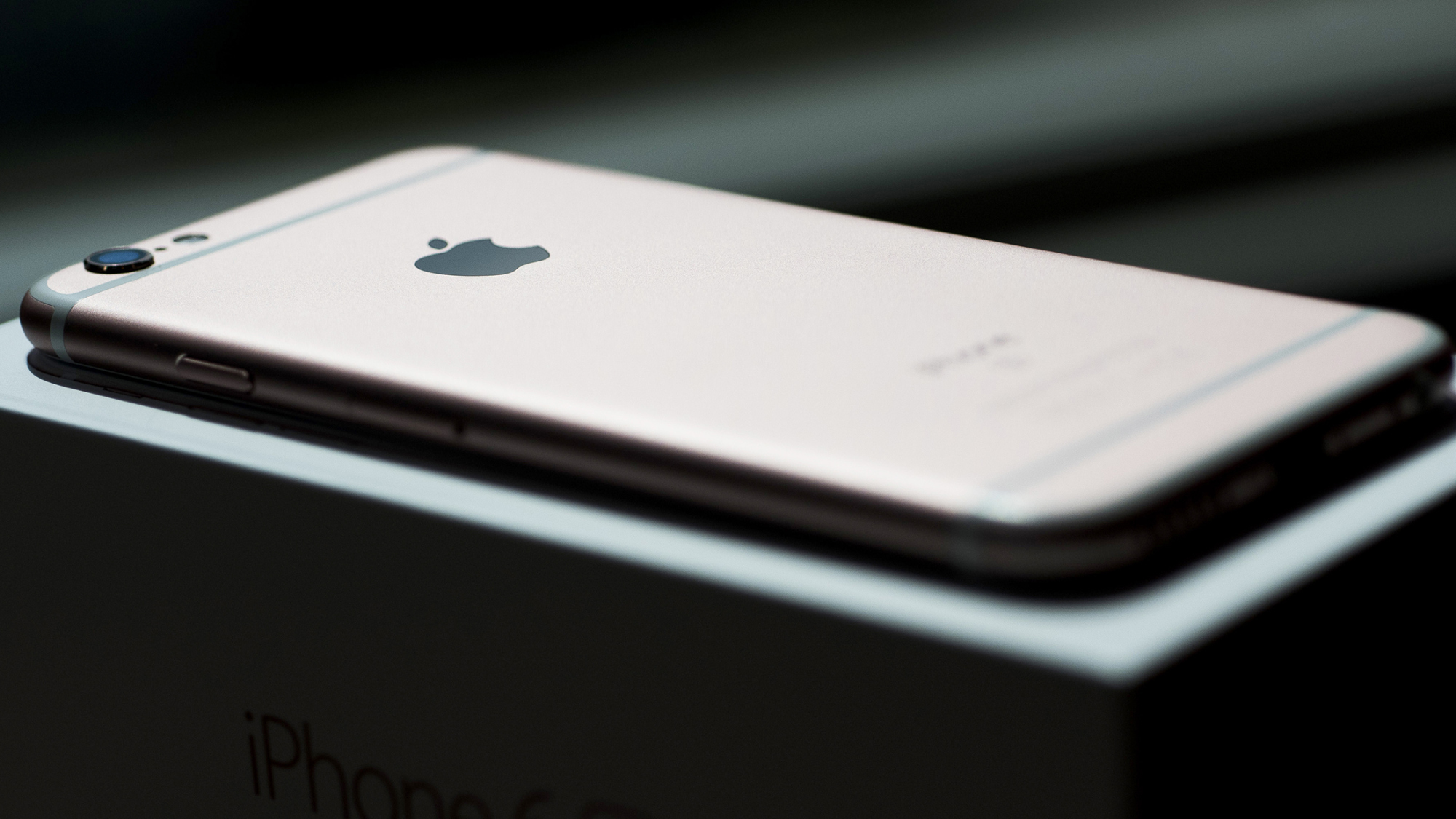 An Apple Inc. iPhone 6s smartphone sits on a packaging box in an arranged photograph.
