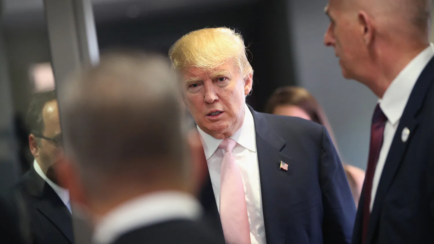 A security team stands guard as Republican presidential hopeful businessman Donald Trump speaks heads to a press conference following a rally on July 25, 2015 in Oskaloosa, Iowa.
