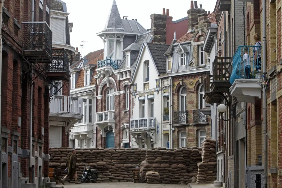 An actor walks on the set before filming a scene for the film, "Dunkirk," in Dunkirk, northern France.