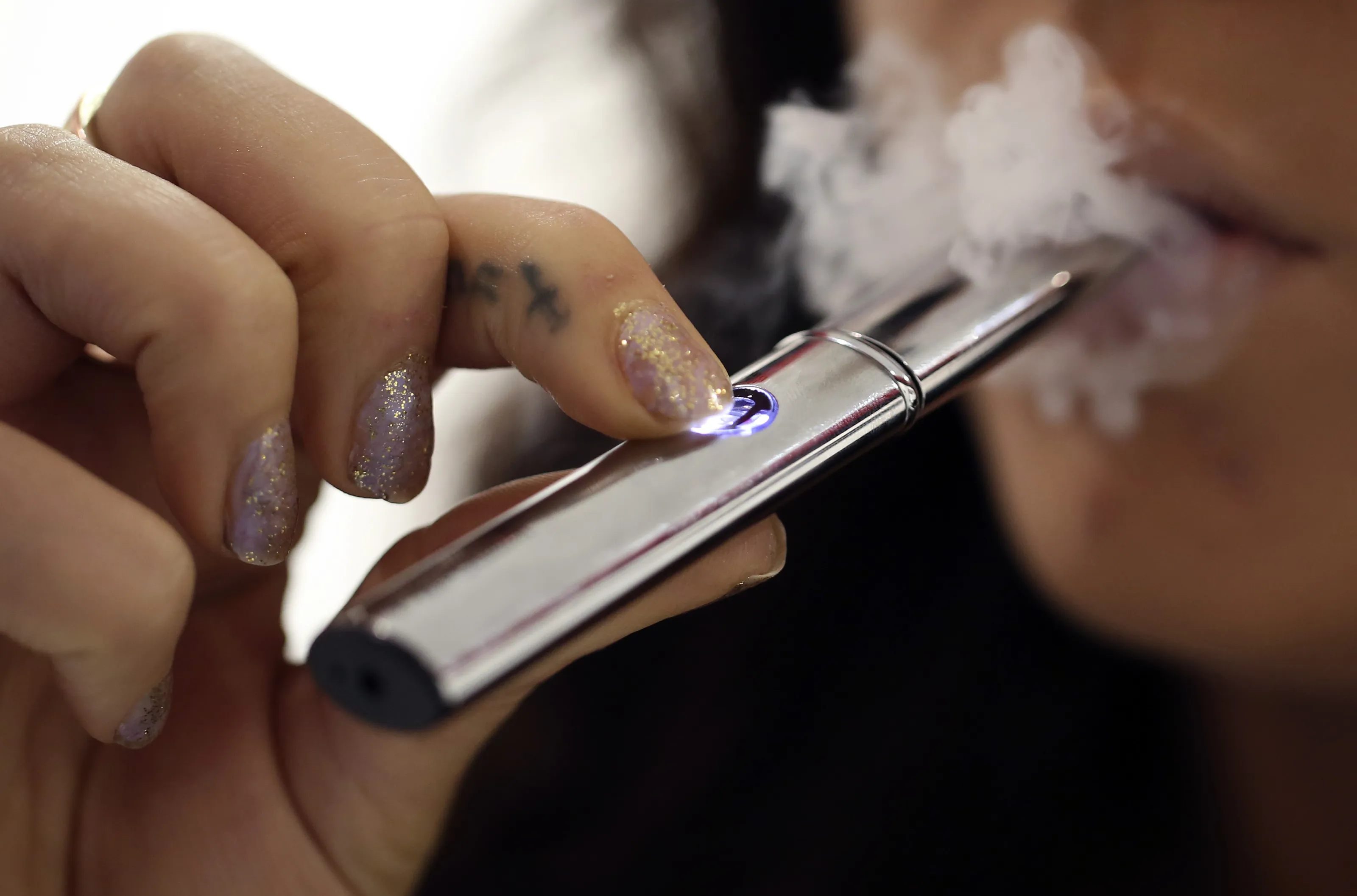 A&nbsp;smoke shop&nbsp;employee uses an e-cigarette.
