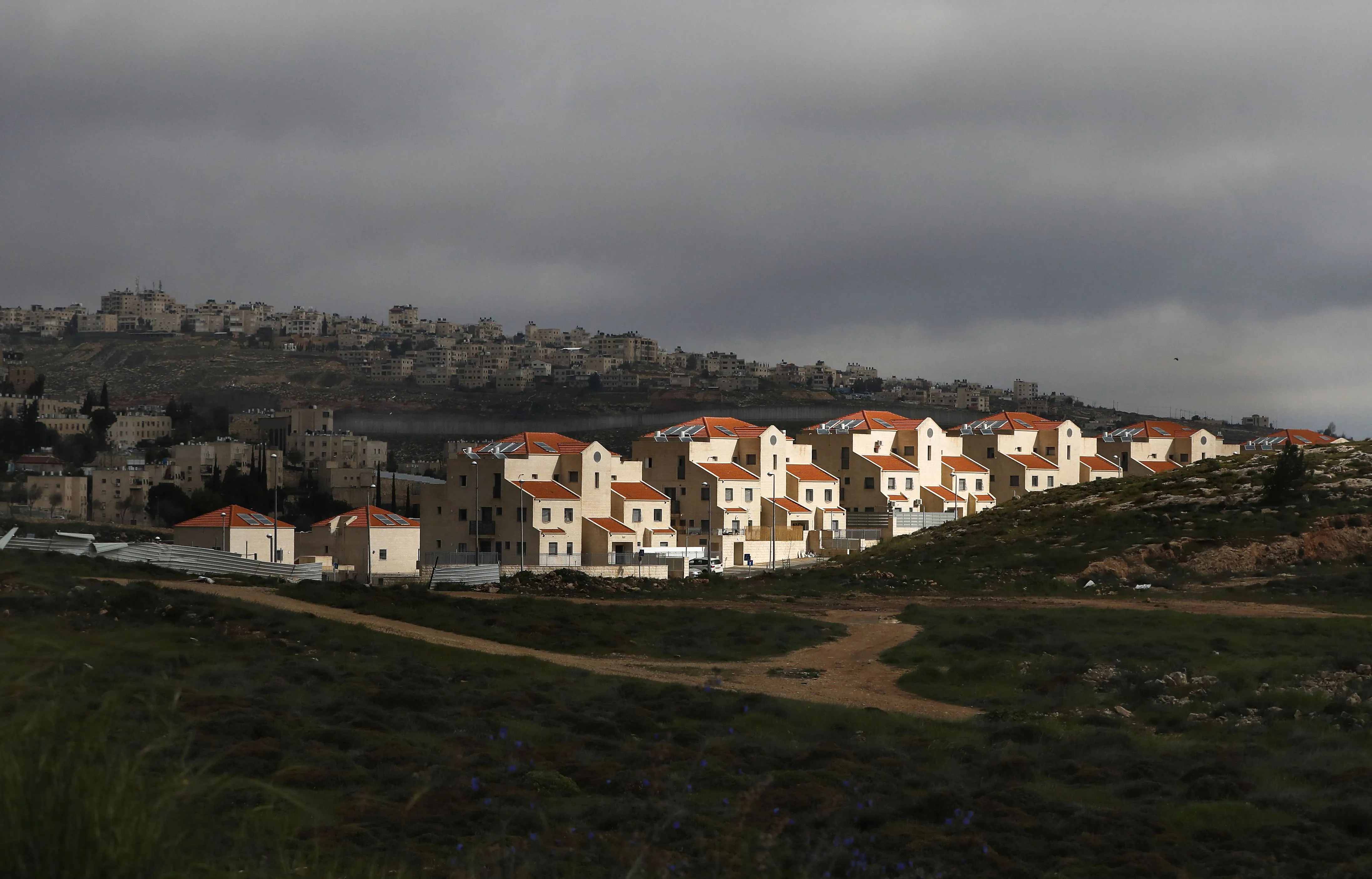 A barrier seperates the Neve Yaakov Jewish settlement with the Palestinian al-Ram neighbourhood in the West Bank.