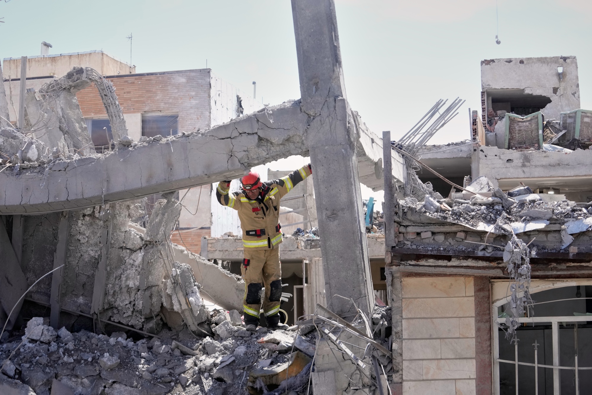 A first responder inspects a building following a strike in Tehran, on March 27. Photographer: Vahid Salemi/AP Photo
