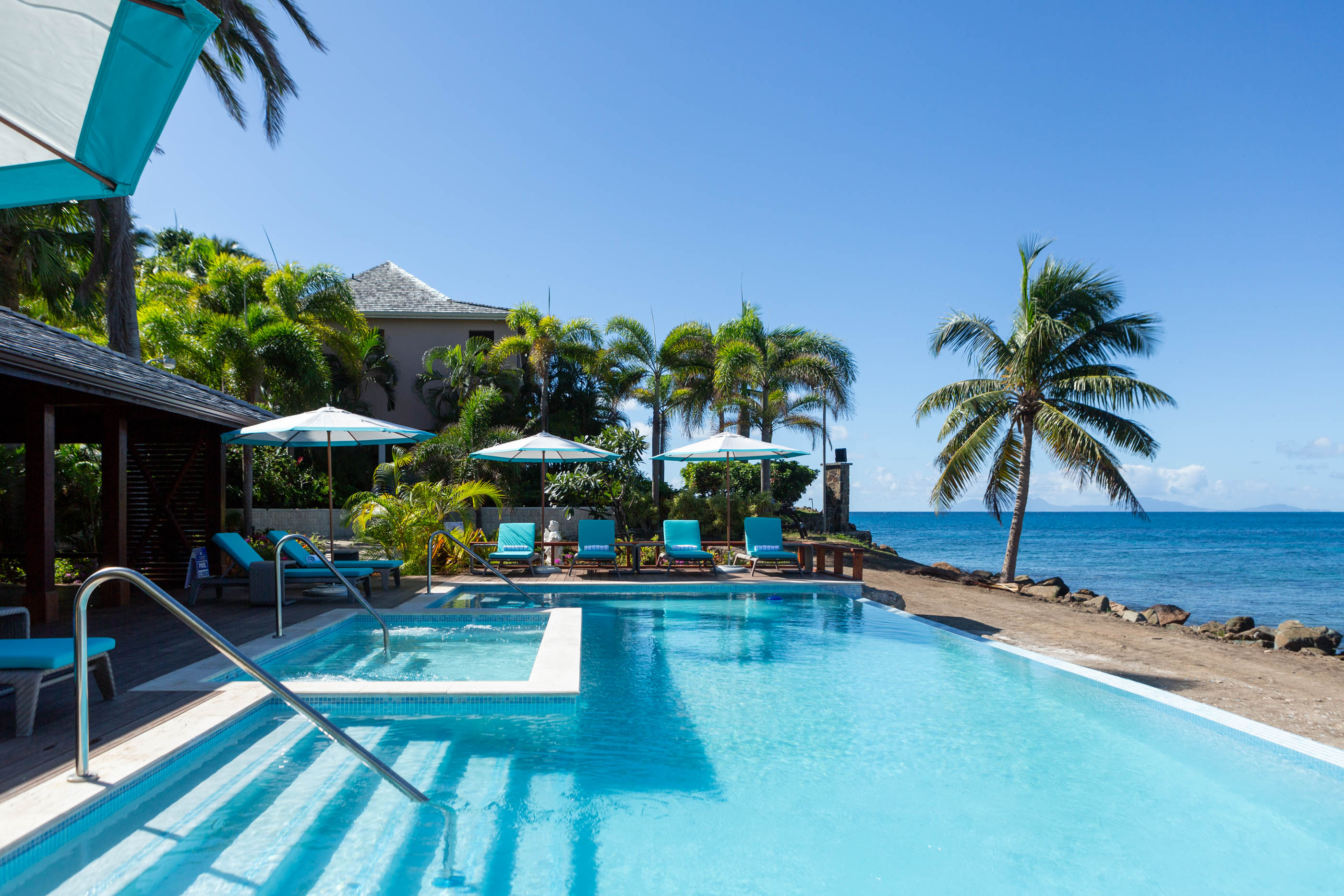 Steps lead into a pool with beach views at Curtain Bluff in Antigua.