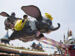Visitors ride on the Dumbo The Flying Elephant ride at Tokyo Disneyland.