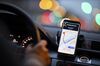 A dashboard-mounted smartphone displays a map of the 'Mainhattan' financial district on the Uber Technologies Inc. app.