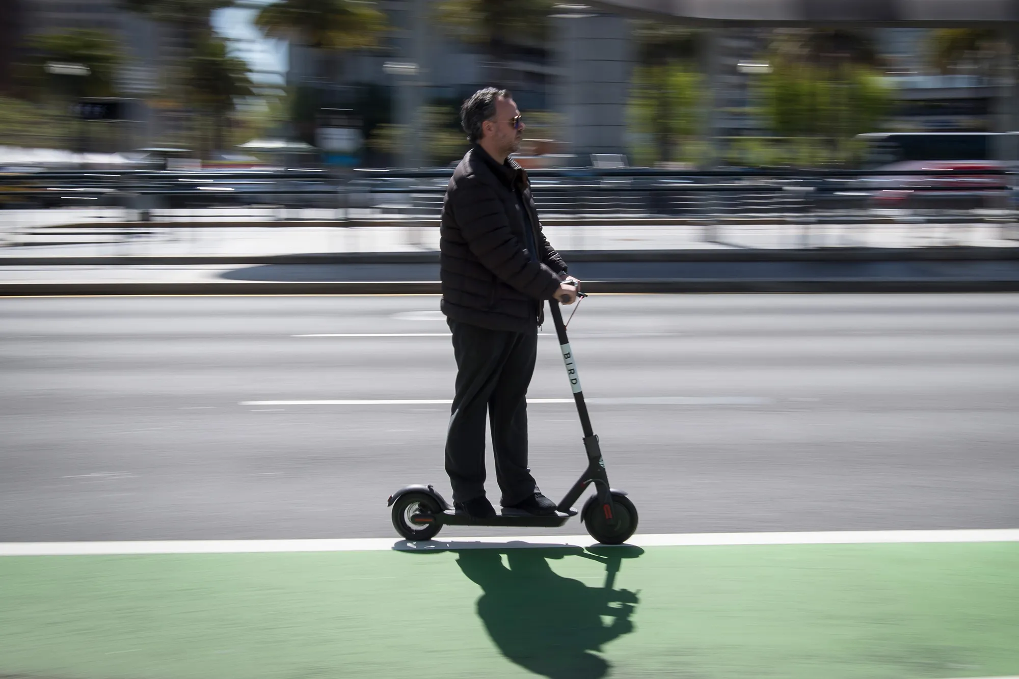 A person rides a Bird Rides Inc. shared electric scooter on the Embarcadero in San Francisco, California.