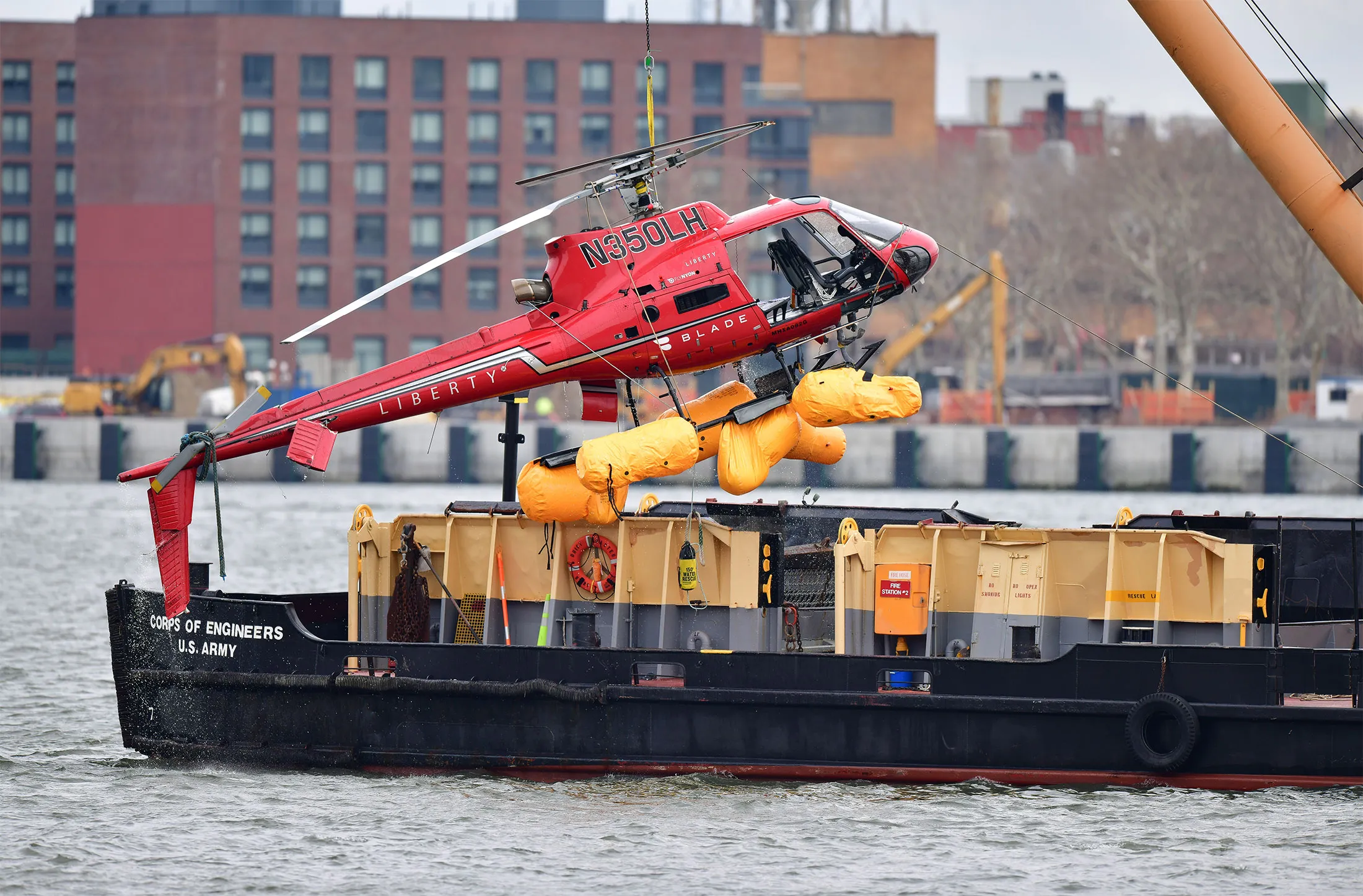A helicopter is pulled from the East River on March 12, 2018 in New York City. Five people died after the helicopter made an emergency landing and flipped upside down on March 11, trapping the passengers inside.