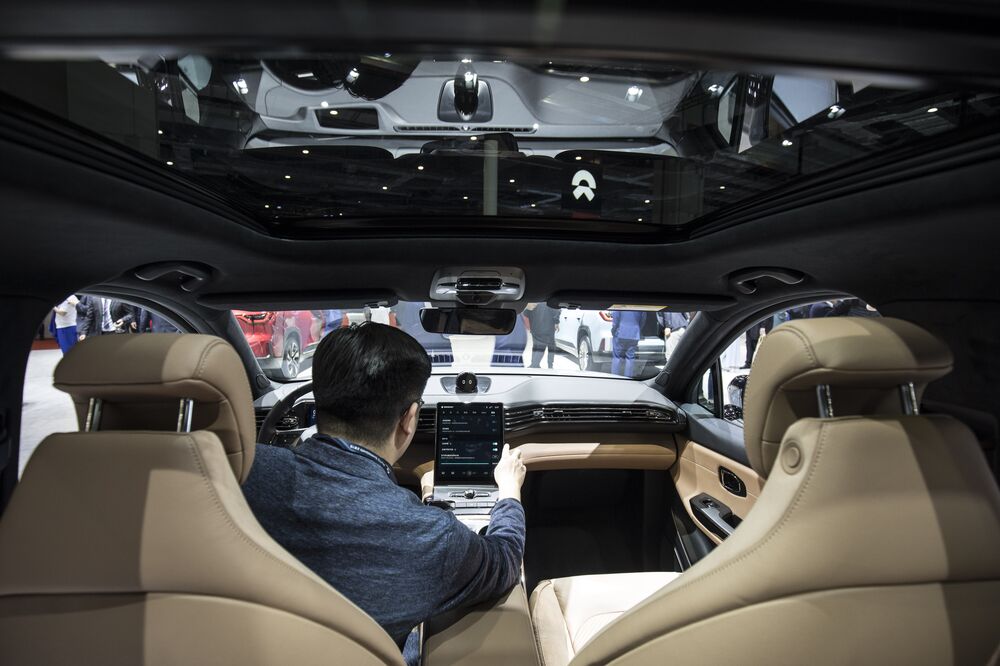 An attendee sits inside the NIO Inc. ES6 SUV on display at the Auto Shanghai 2019.