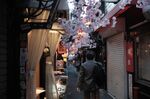 A pedestrian walks through the Omoide-Yokocho alleyway in the Shinjuku district of Tokyo, Japan.
