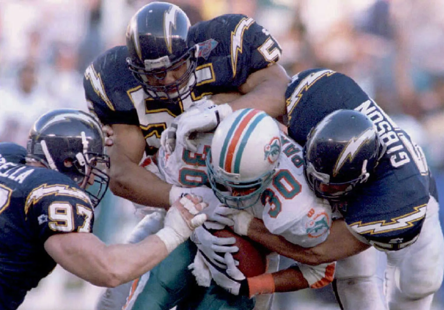 A Miami Dolphins player is tackled by San Diego Chargers players in San Diego.