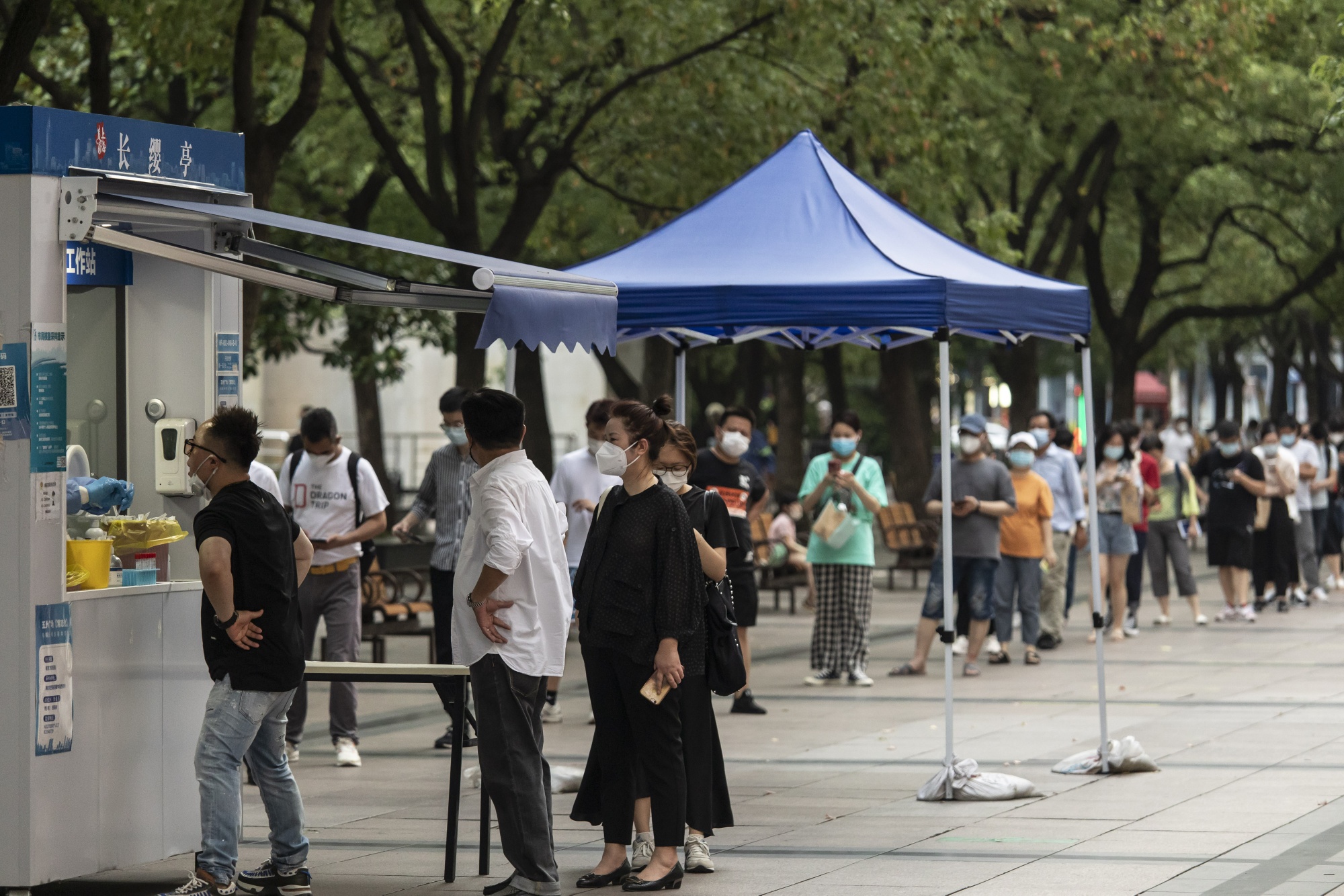 Office workers line up at a Covid-19 testing booth in downtown Shanghai&nbsp;on July 13.