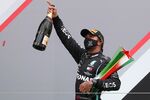Lewis Hamilton celebrates on the podium after winning the Portuguese Formula One Grand Prix at the Autodromo Internacional do Algarve on Oct. 25.