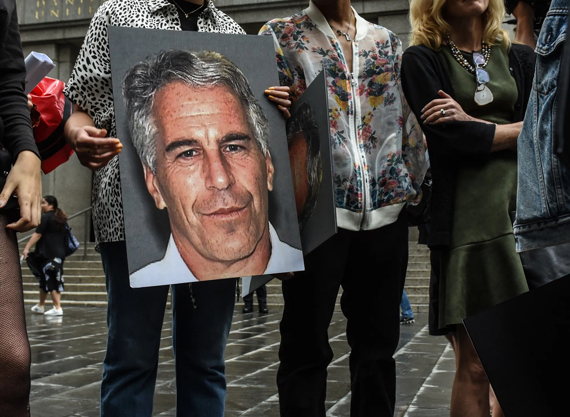 A protest group holds up signs of Jeffrey Epstein in front of the Federal courthouse in New York in 2019.