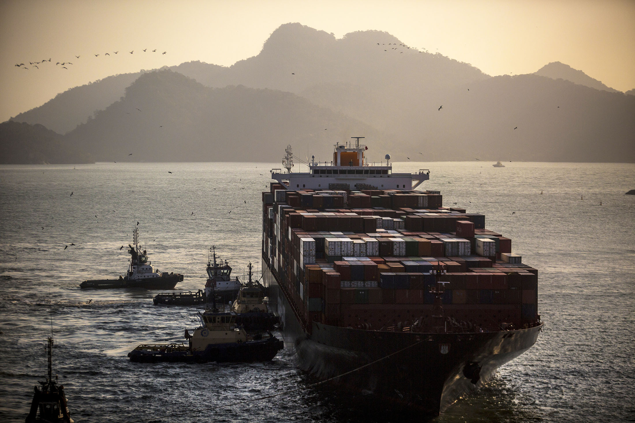 Tugboats assist a container ship at&nbsp;the Port of Itaguai in Rio de Janeiro, Brazil.