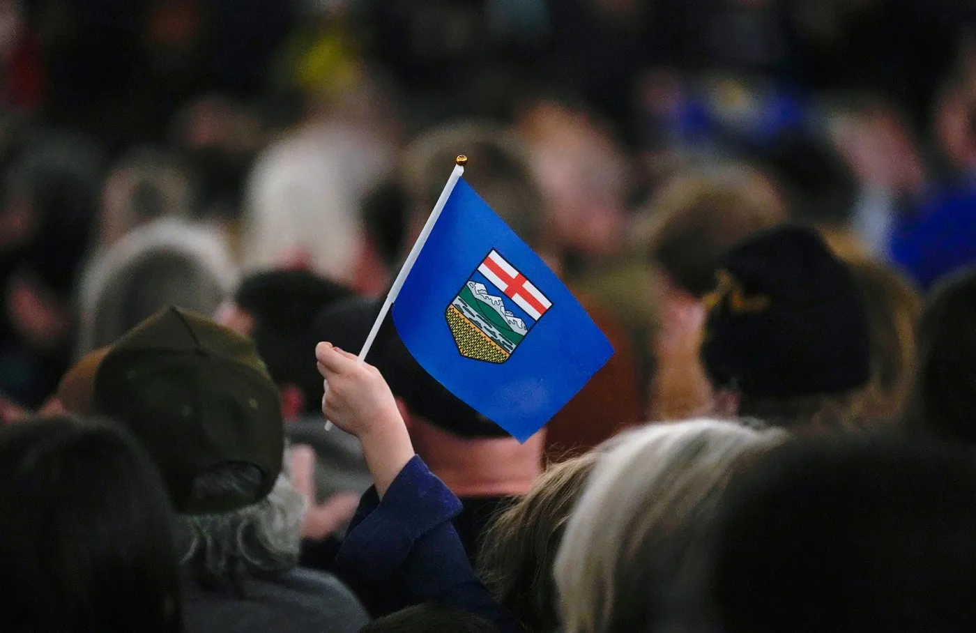 An attendee holds an Alberta flag during the Alberta Independence Town Hall event in Calgary on Jan. 26.