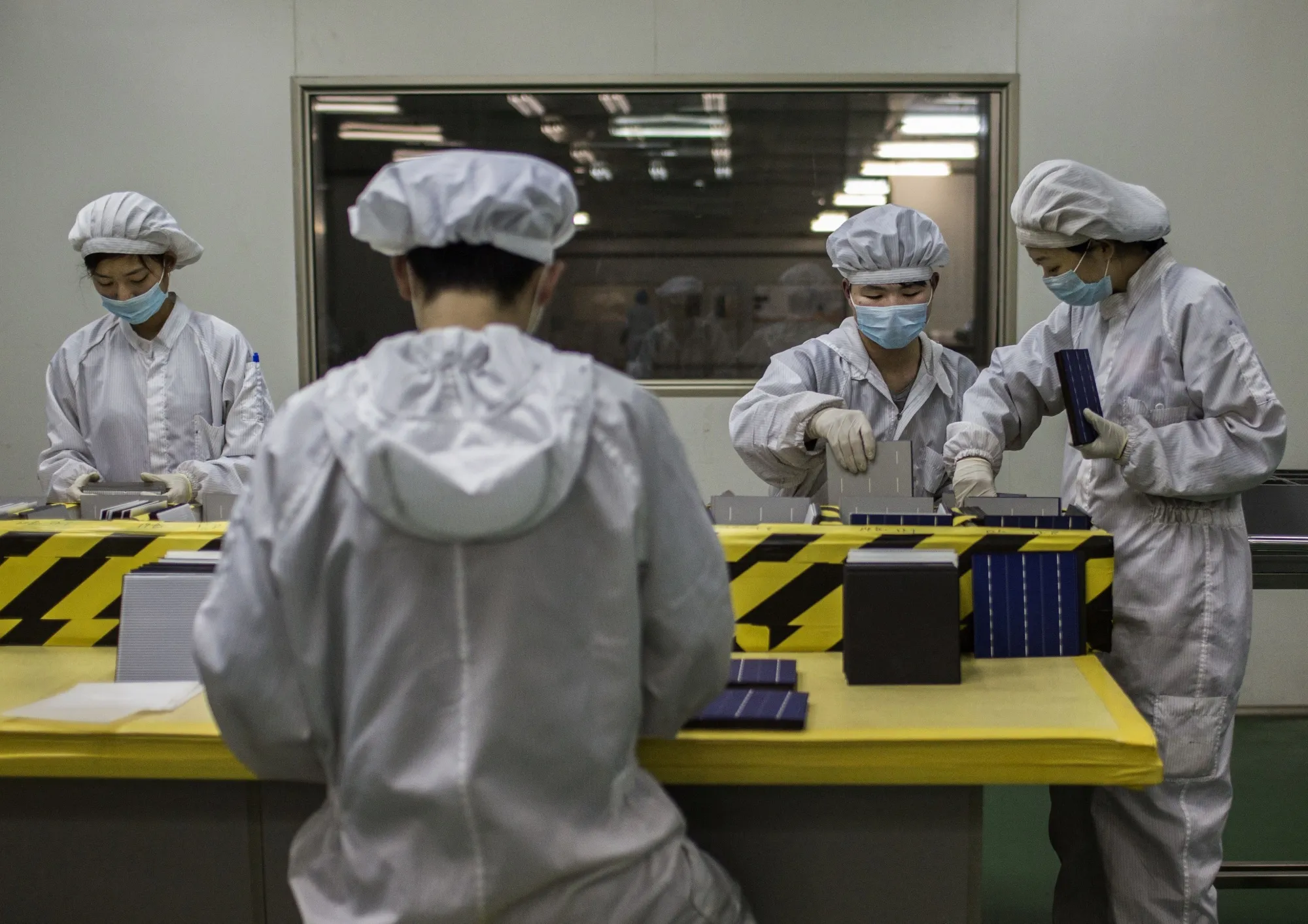 Technicians&nbsp;work on solar cells used for solar panels&nbsp;in Baoding, China.