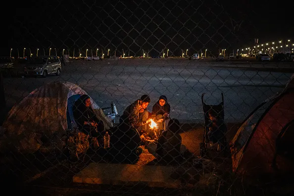 Displaced family members sit around a fire outside their tent along the seafront in Beirut on March 18. Israel has killed hundreds of Lebanese in a&nbsp;bombing campaign it says is directed at Iranian ally Hezbollah, part of what’s become a&nbsp;wider regional war.