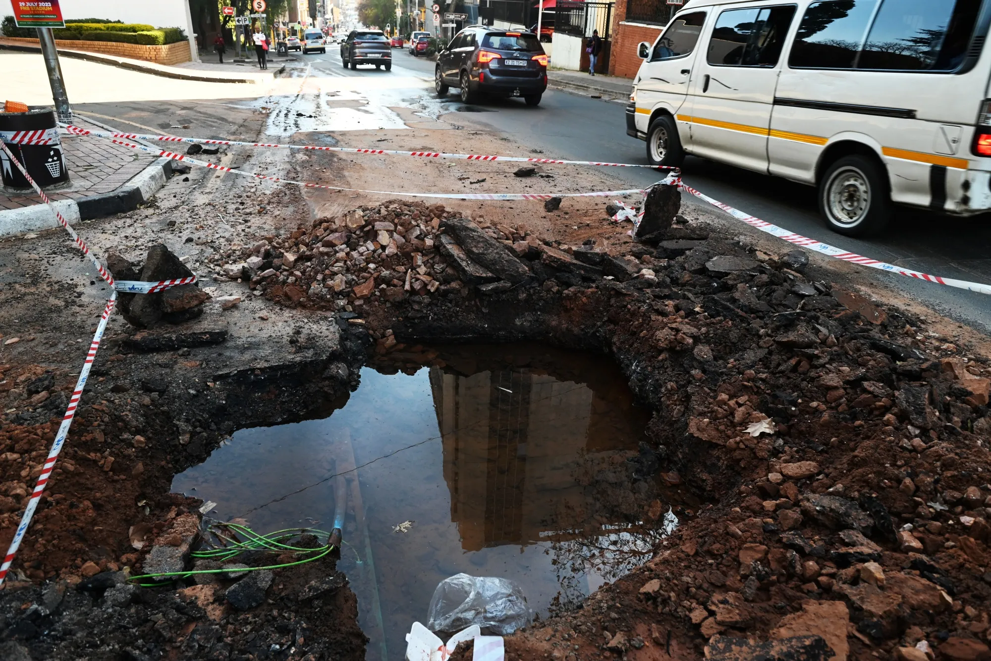 Traffic navigates a hole on a road in Johannesburg.