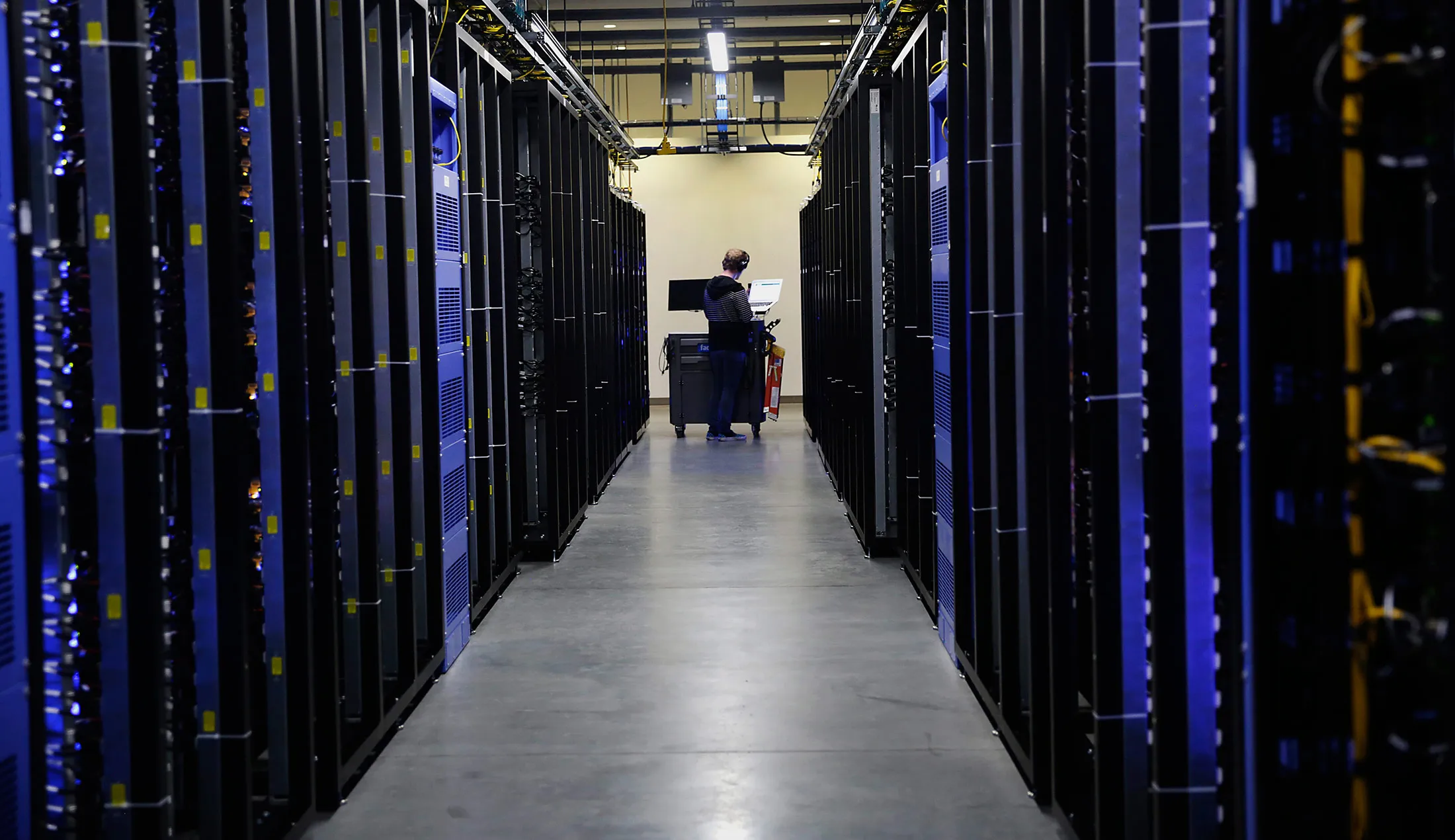An employee fixes part of a web server inside the Facebook Inc. Prineville Data Center in Prineville, Oregon.