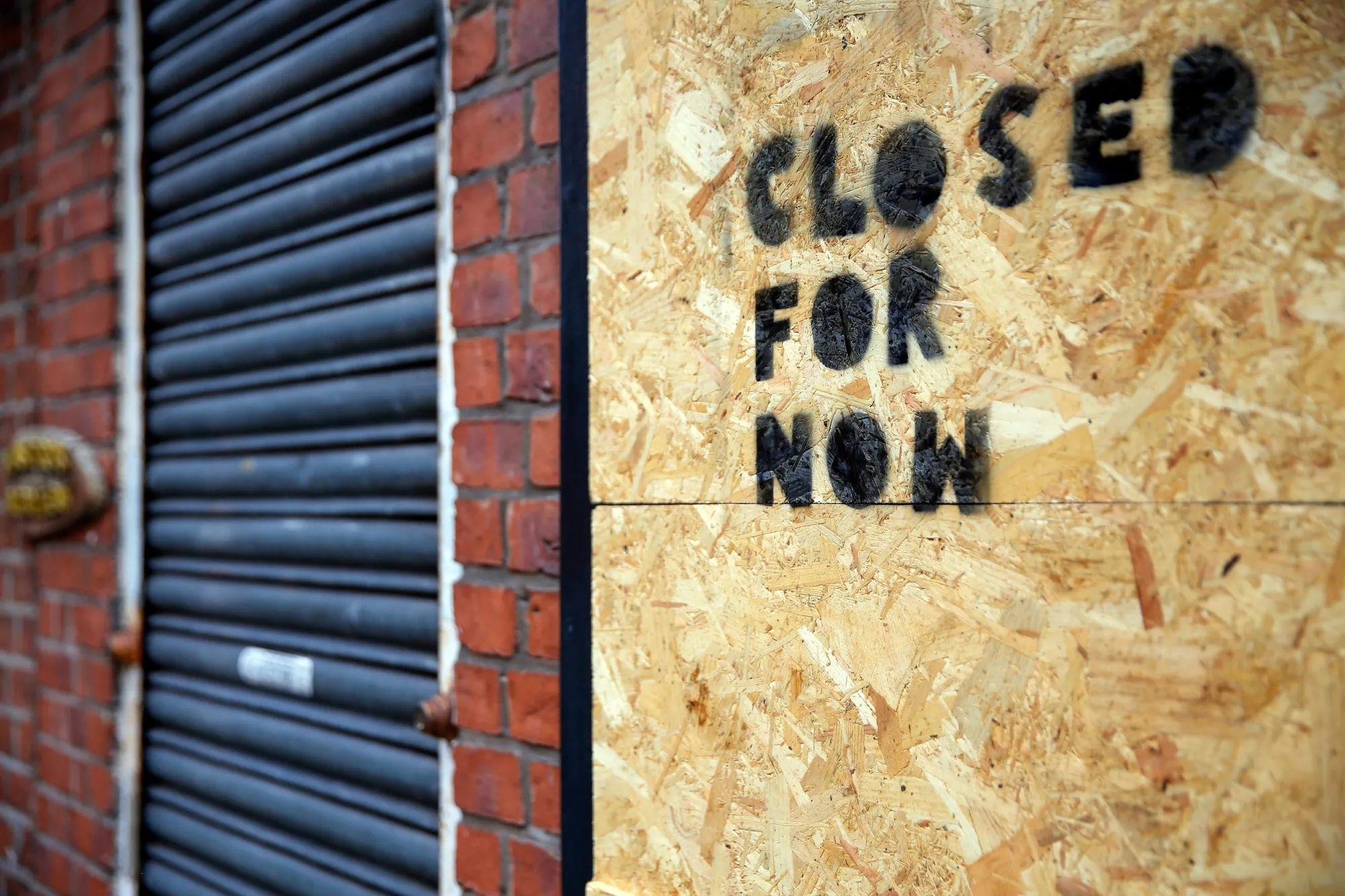 A boarded up window with a message reading 'Closed for Now' sits on a restaurant in Manchester, U.K.