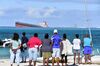 Bystanders look at the MV Wakashio bulk carrier which is leaking oil near Blue Bay Marine Park in Mauritius on Aug. 6