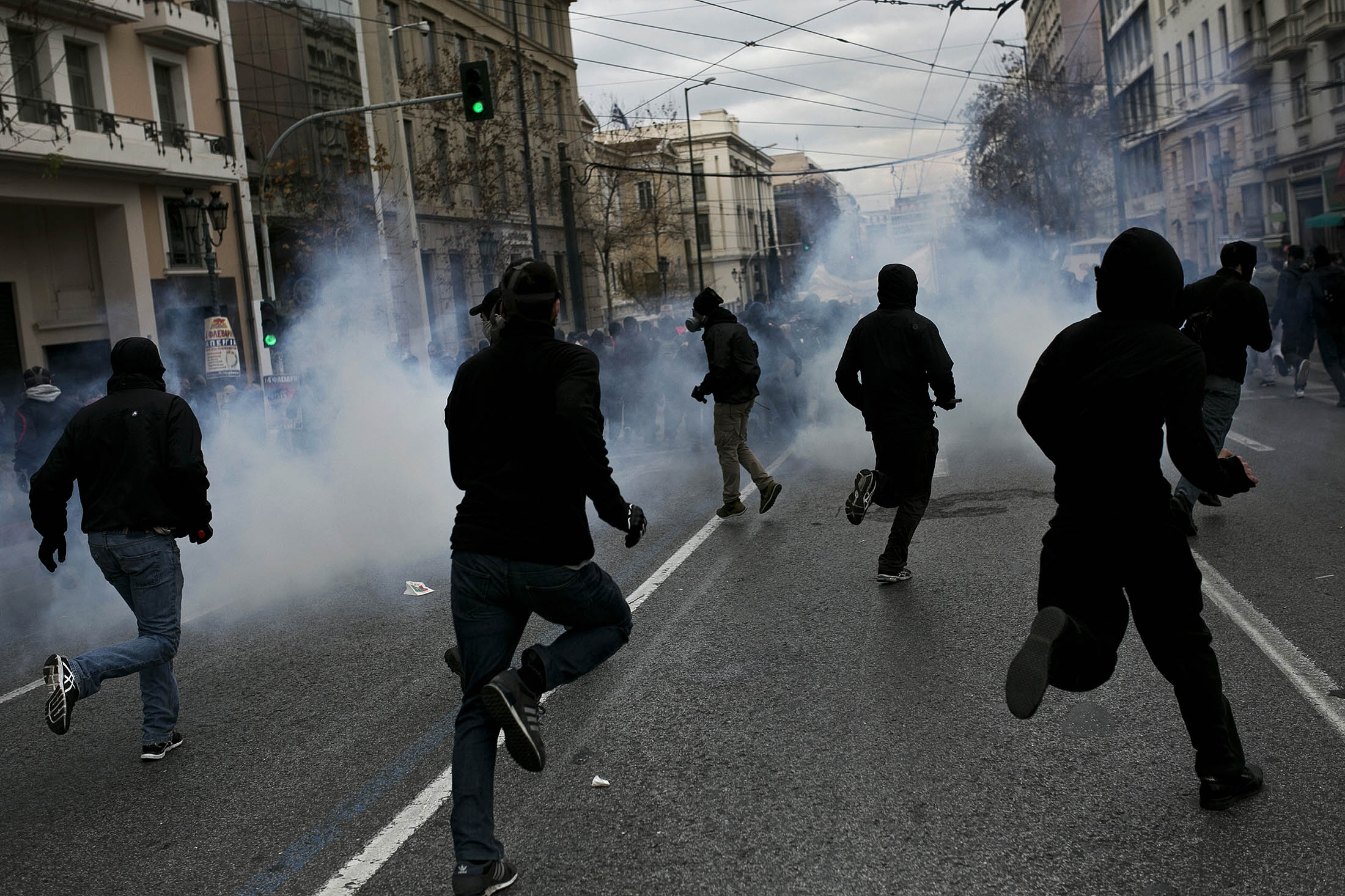 Demonstrators run among tear gas during a massive protest next to the Greek parliament in Athens.
