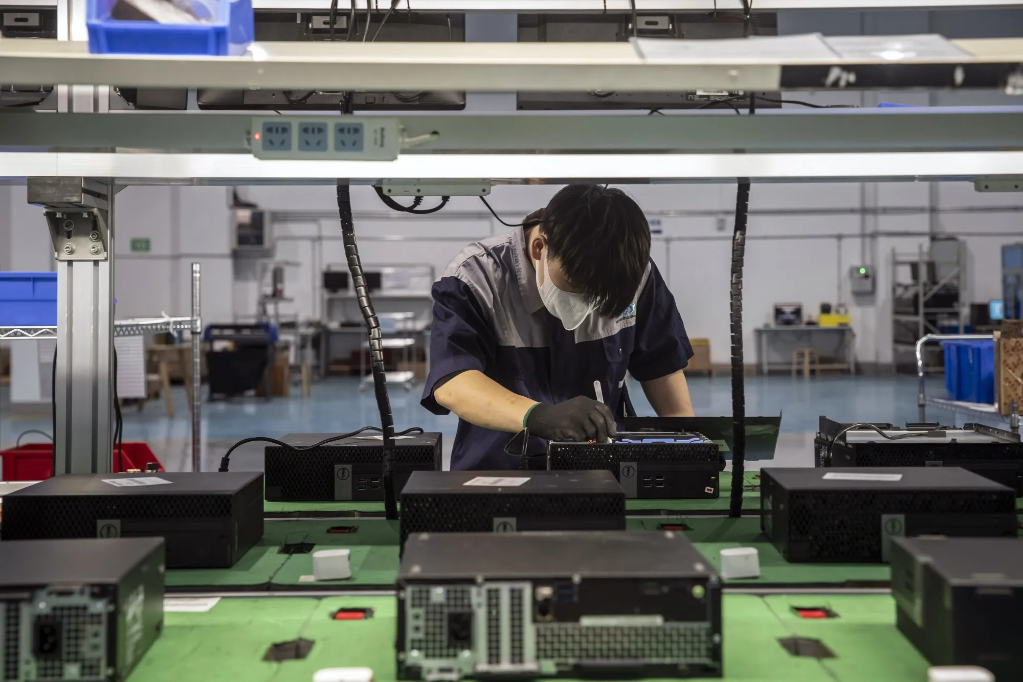 An employee on an assembly line for refurbished computer consoles&nbsp;in Shanghai.