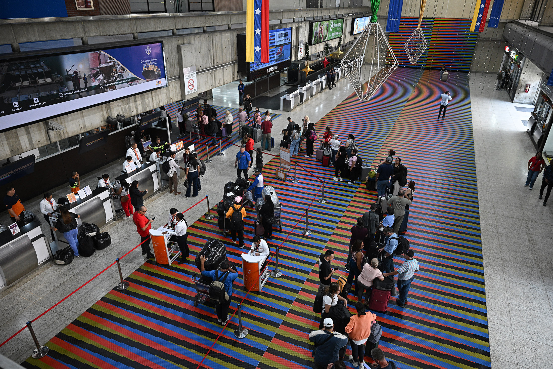 Passengers wait at check-in counters at Simon Bolivar International Airport in Maiquetia, La Guaira State, Venezuela, on Nov. 27.