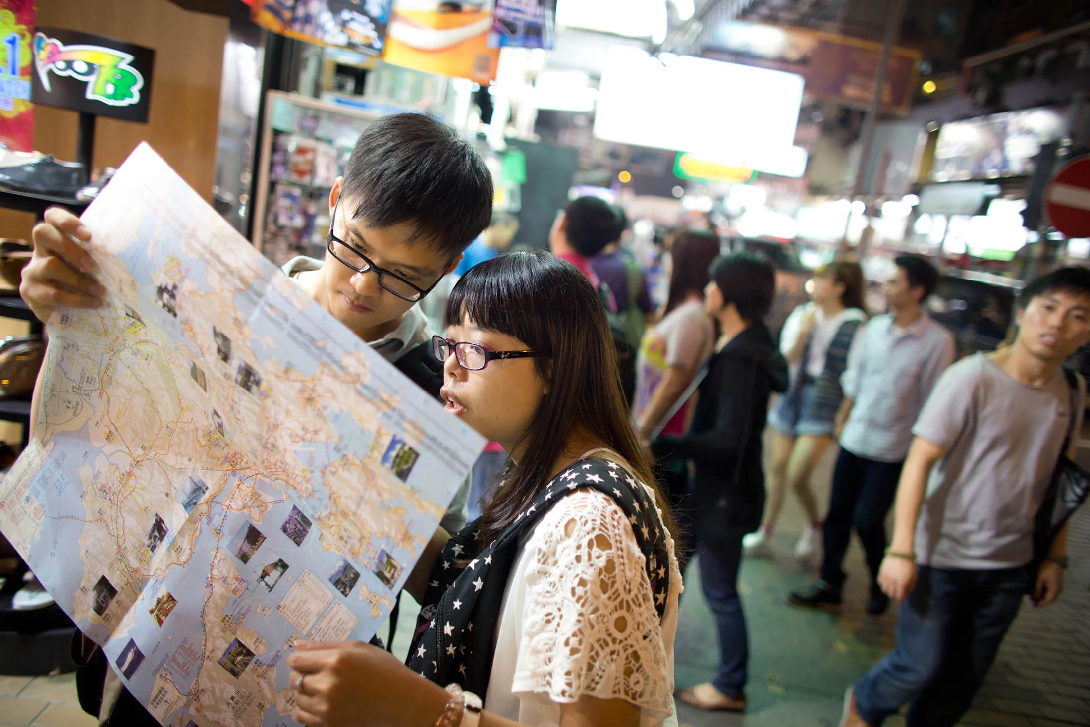 Tourists look at a map in the shopping district of Mong Kok in Hong Kong. The number of Chinese tourists flocking to Macau and Hong Kong during the Golden Week holidays increased at a slower pace than last year.
