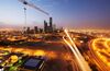 A construction crane sits above an illuminated highway leading past the King Abdullah financial district, center, in Riyadh, Saudi Arabia, on Friday, Jan. 8, 2016. Saudi Arabian stocks led Gulf Arab markets lower after oil extended its slump from the lowest close since 2004.