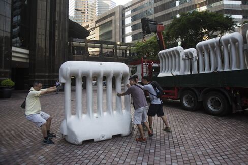 Workers move a barricade ahead of a visit by Zhang Dejiang on Monday. Photographer: Justin Chin/Bloomberg
