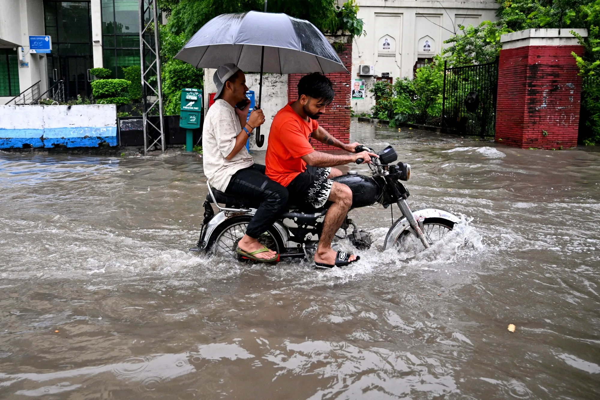 Commuters ride through a flooded road&nbsp;in Lahore on Aug. 30.&nbsp;