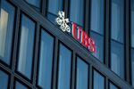 An illuminated UBS logo sits above office windows outside a bank branch, operated by UBS Group AG, in Zurich, Switzerland, on Feb. 10, 2015. .