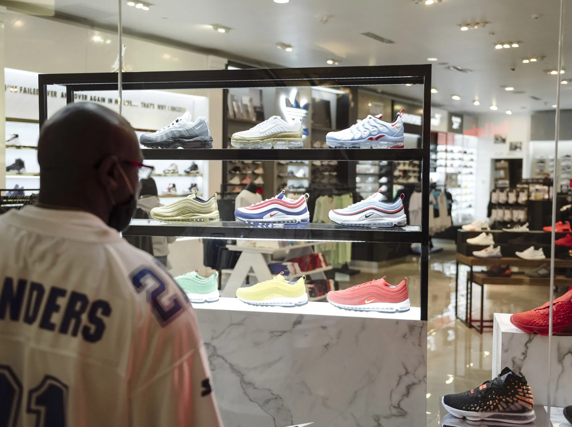 A shopper browses sneakers displayed in the window of a store in San Francisco.