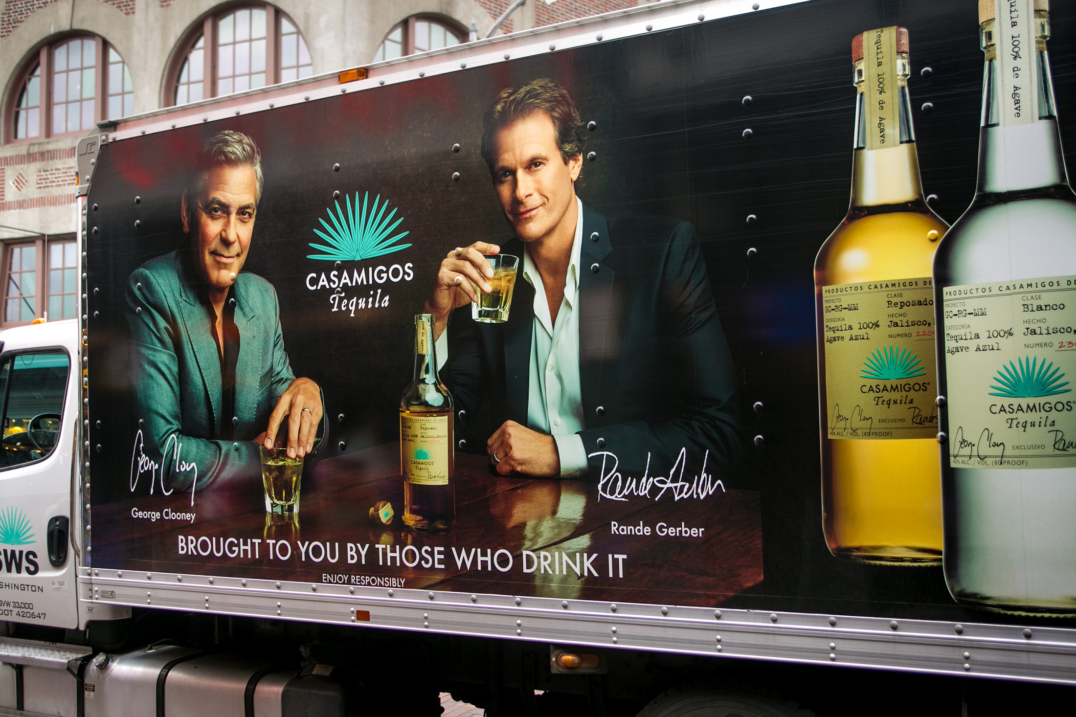 The side of a delivery truck features a billboard promoting George Clooney and Rande Gerber's Casamigos Tequila
