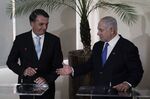 Benjamin Netanyahu shakes hands with Jair Bolsonaro on Friday.