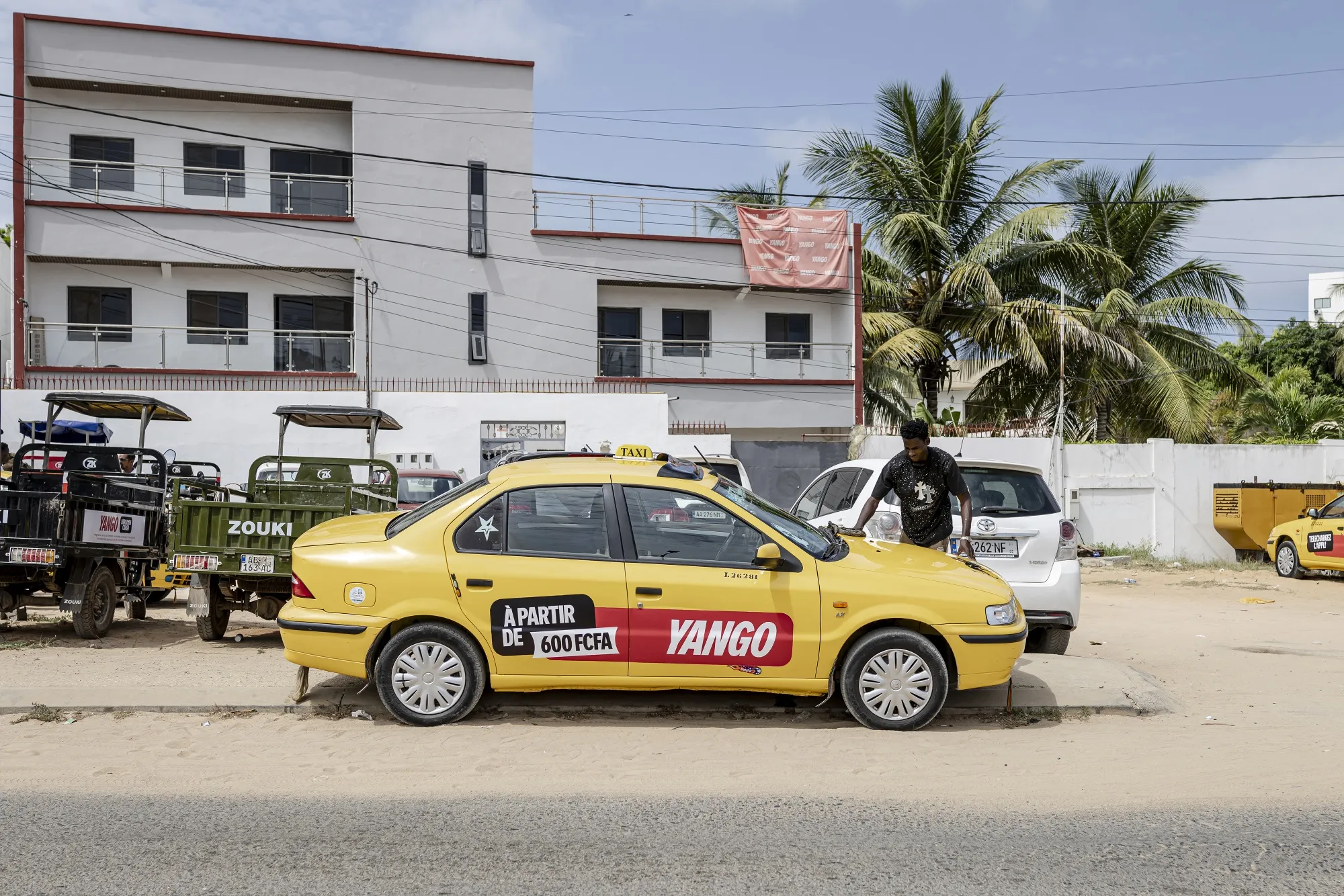 A driver cleans a car belonging to a Yango fleet at their office in Dakar in 2025.