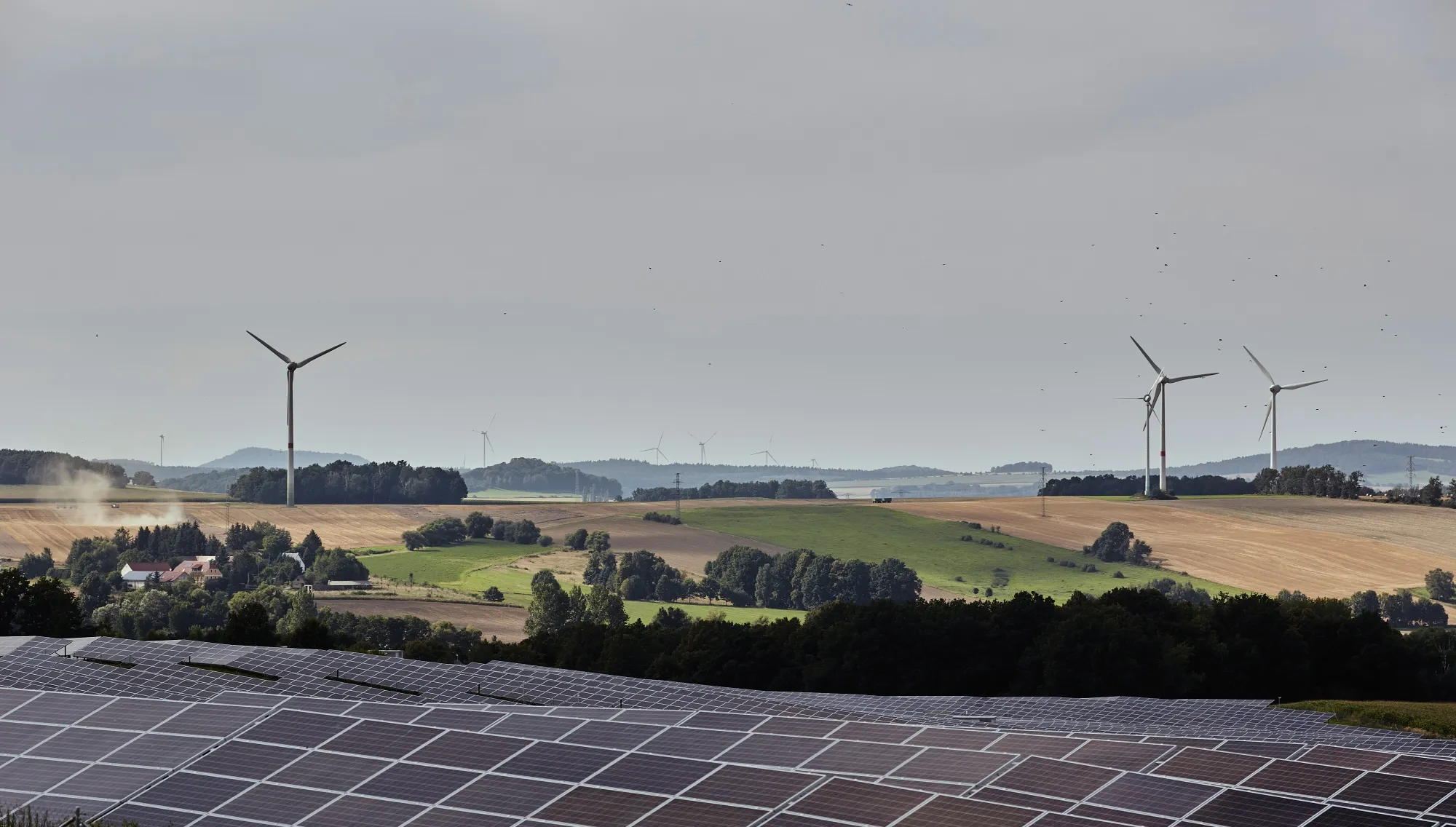 Solar panels and near wind turbines in Bogatynia, Poland.