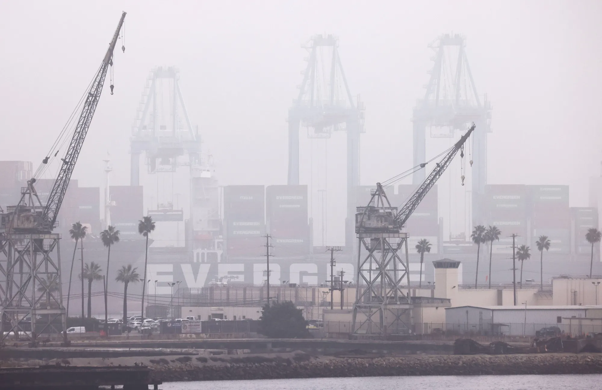 Shipping containers are visible through fog stacked on a container ship at the Port of Los Angeles&nbsp;in San Pedro.