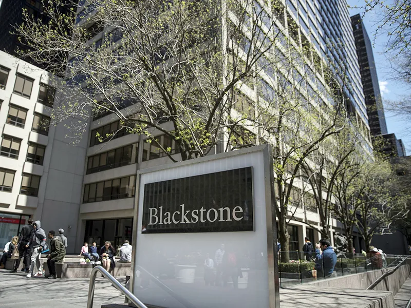 Pedestrians pass by the headquarters of Blackstone in midtown Manhattan in New York.