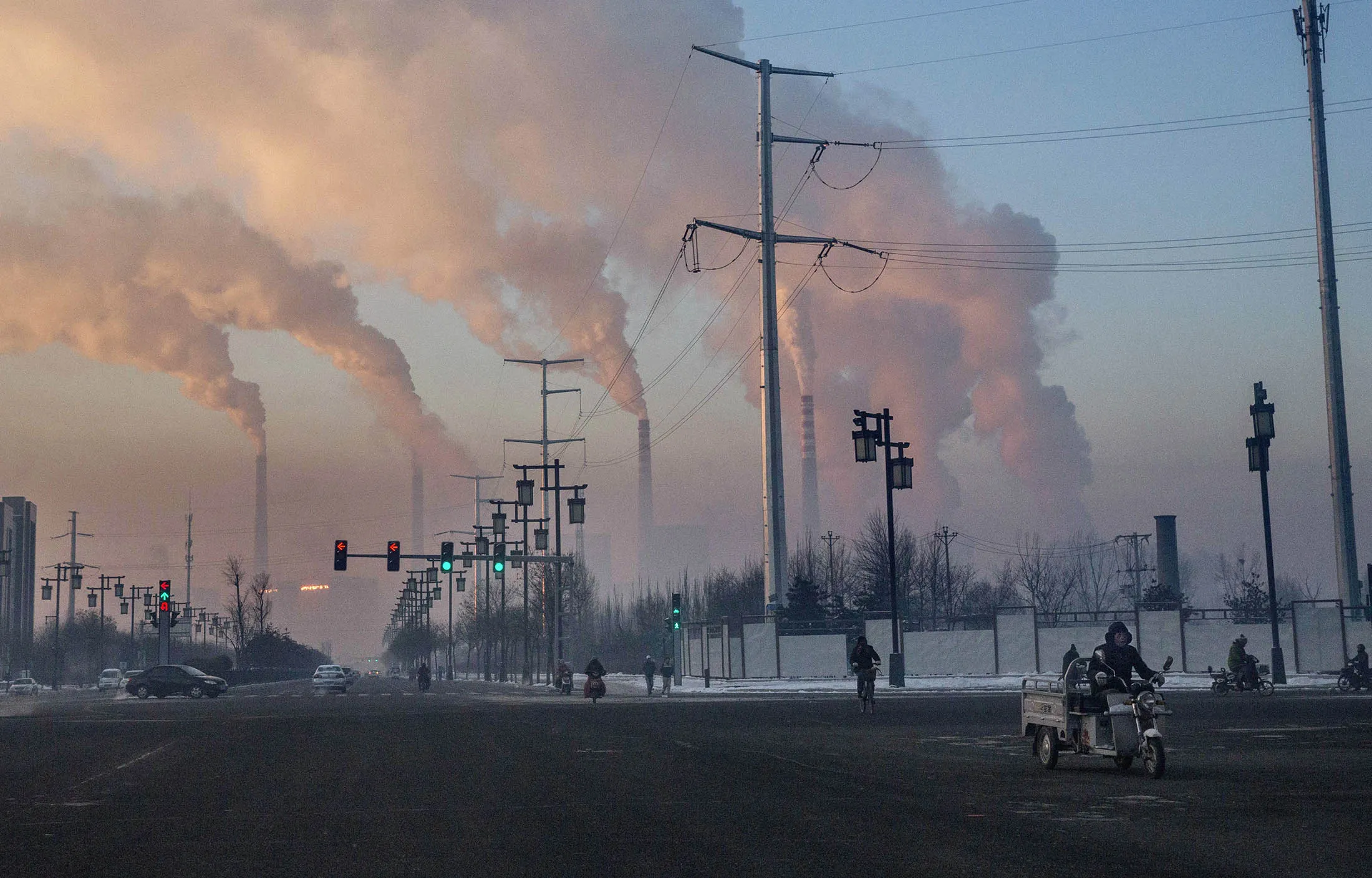 SHANXI, CHINA -NOVEMBER 25: (CHINA, HONG KONG, MACAU, TAIWAN OUT) Chinese workers commute as smoke billows from a coal fired power plant on November 25, 2015 in Shanxi, China. A history of heavy dependence on burning coal for energy has made China the source of nearly a third of the world's total carbon dioxide (CO2) emissions, the toxic pollutants widely cited by scientists and environmentalists as the primary cause of global warming. China's government has publicly set 2030 as a deadline to reach the country's emissions peak, and data suggest the country's coal consumption is already in decline. The governments of more than 190 countries are expected to sign an agreement in Paris to set targets on reducing carbon emissions in an attempt to forge a new global agreement on climate change.
