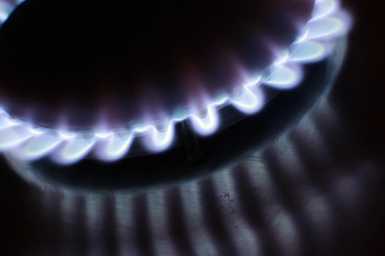 A gas ring burns on a stove in London, U.K., on Sunday, Dec. 18, 2011. Electricity and gas supply plunged 4.9 percent, as the warmest October since 2006 curbed energy demand.