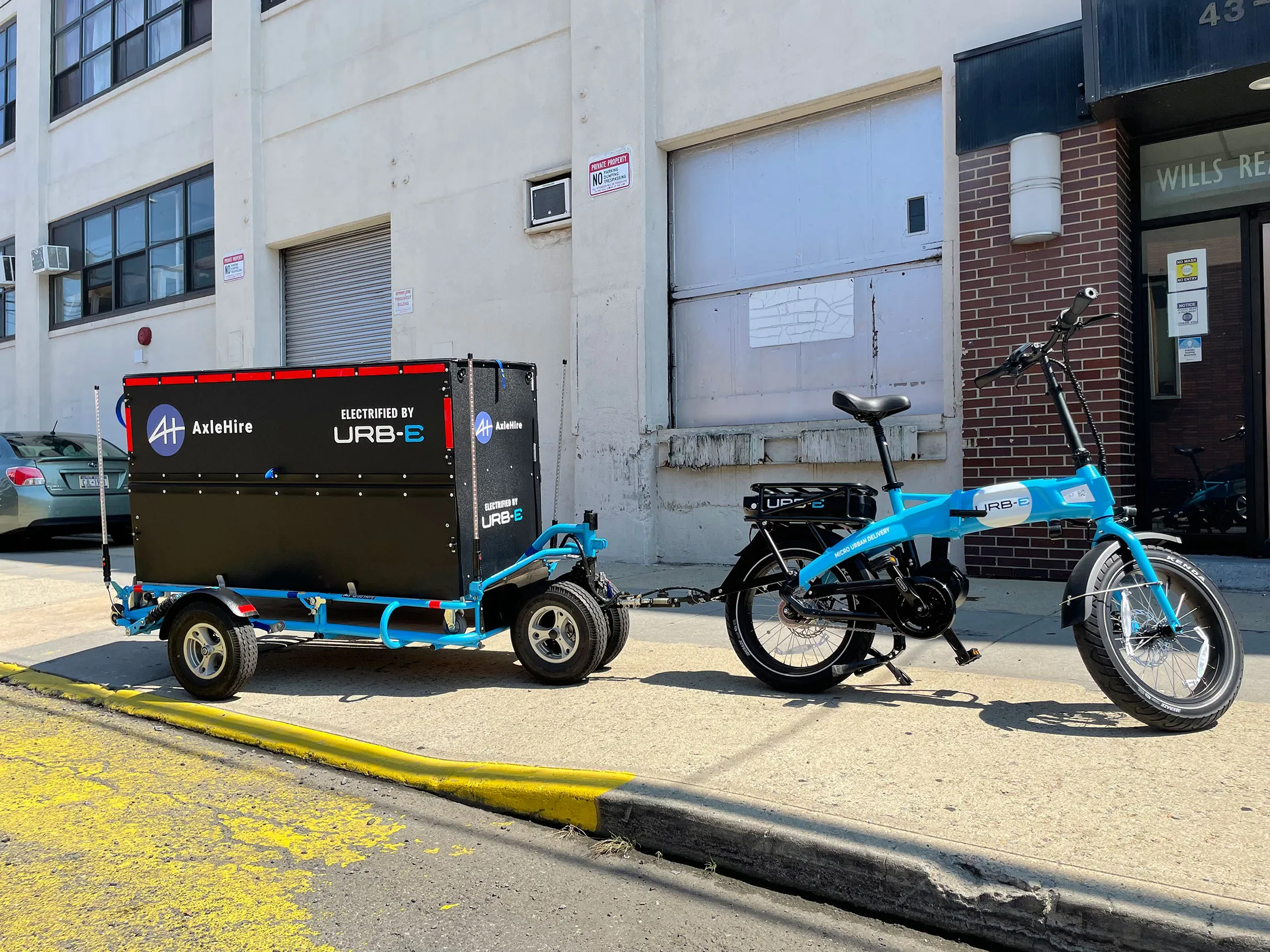 An URB-E cargo bike hitched with a container.