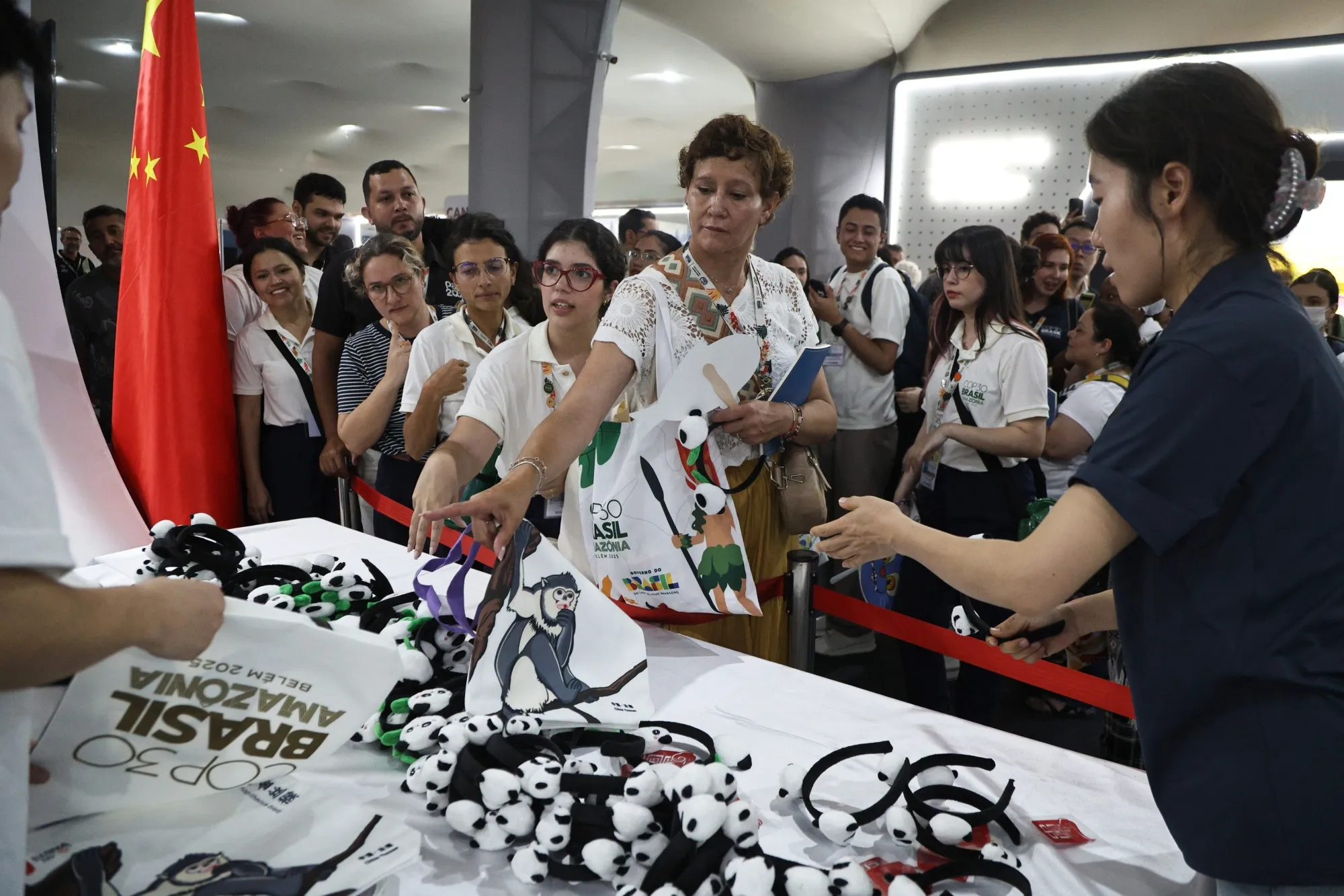 Participants line up for souvenirs at the China Pavilion during the COP30 in Belém, Brazil.